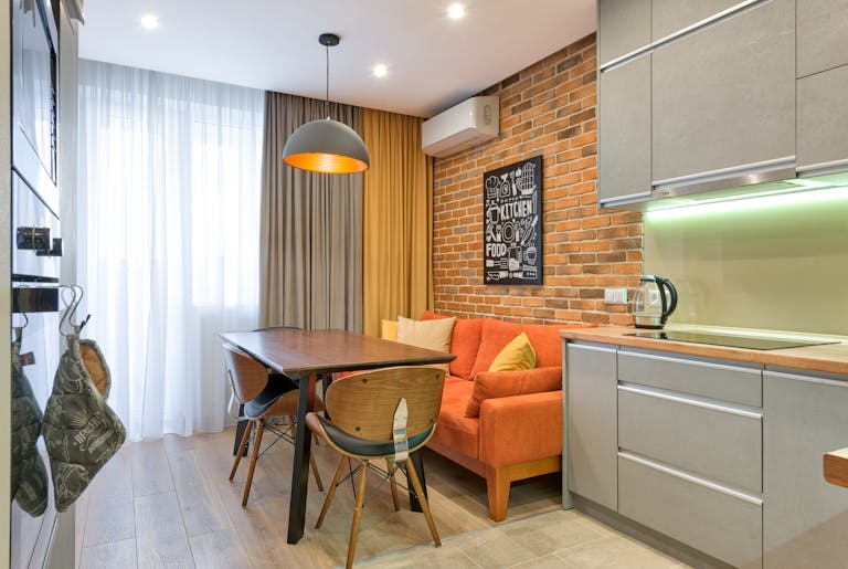 Modern kitchen with brick wall and minimalist furniture in a cozy apartment.